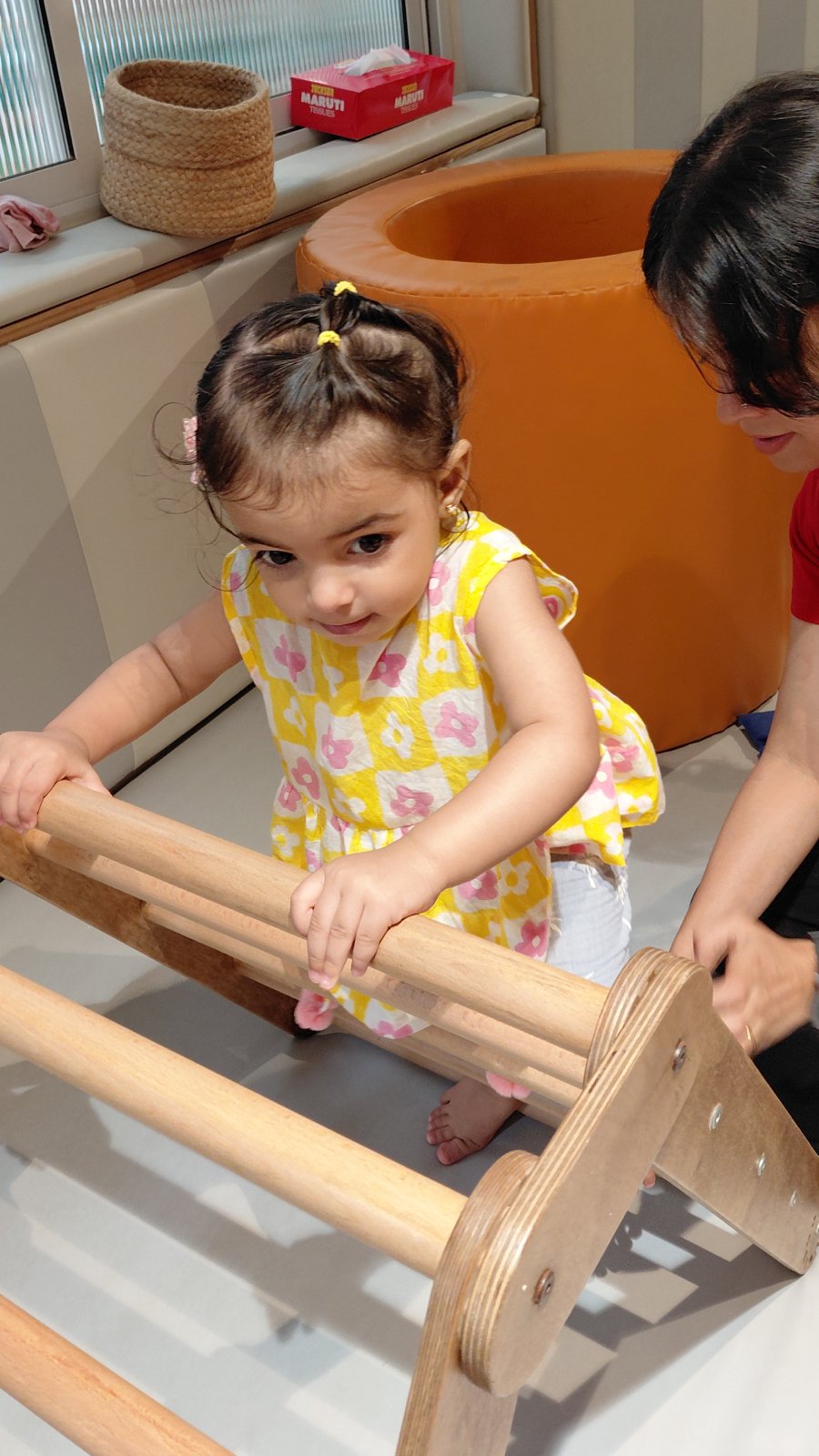 Facilitator observing a toddler closely during play at Circles & Cycles, Bandra