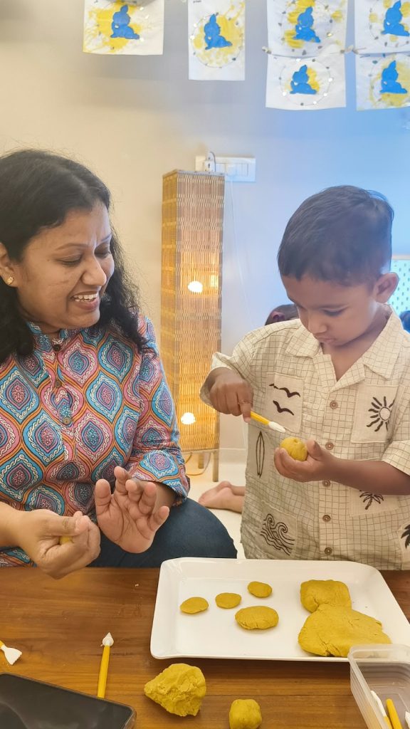 Facilitator gently guiding a toddler's hands to show soft touch at Circles & Cycles, Bandra
